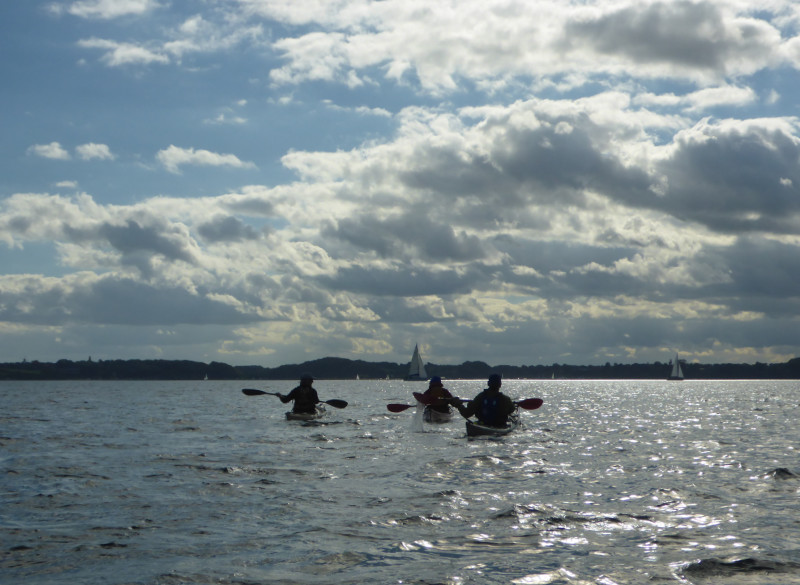 Drei Paddelnde auf der Ostsee, mit Wolkenkulisse